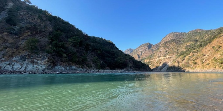 A picture of a river in Rishikesh, Uttarakhand with views of mountains in the background