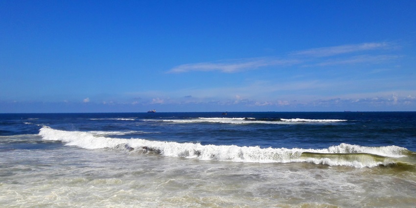A majestic view of a beach in Visakhapatnam with waves approaching the shore