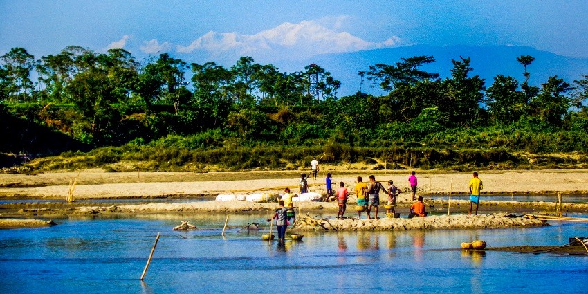 People collecting stones from a riverbank