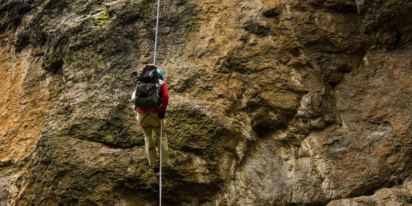 An adventure enthusiast climbing a huge rock