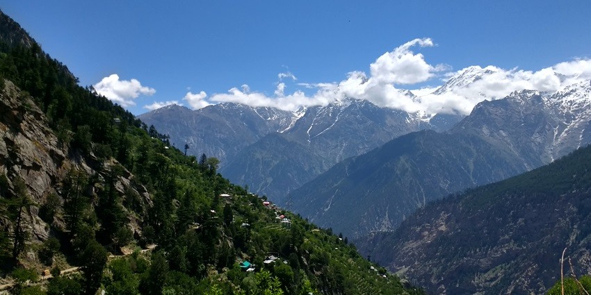 A breathtaking view of Roghi Village that exhibits lush greenery and scenic mountains.