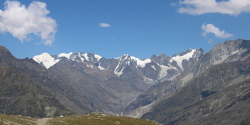 Scenic view of snow-capped mountains and lush greenery on the Manali to Rohtang Pass road.