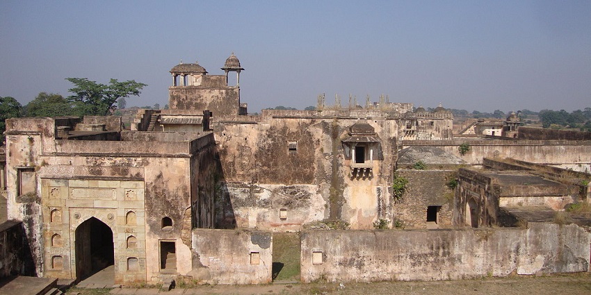 Inside view of Rohtasgarh Fort with ancient stone structures, arches, and overgrown vegetation.