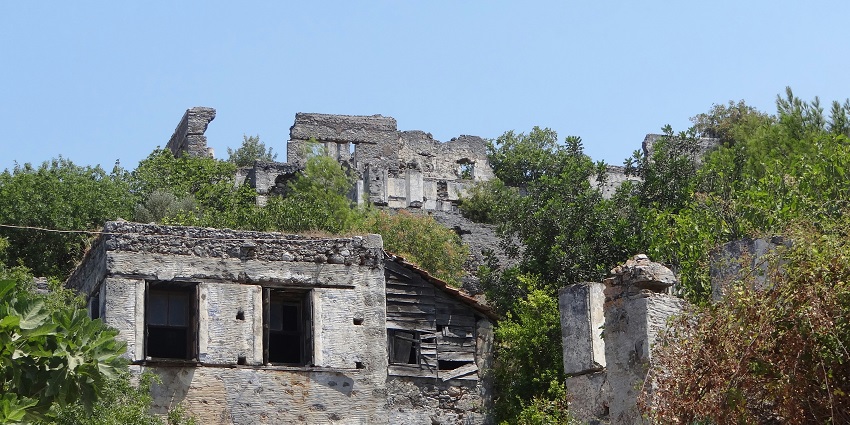 Fort ruins nestled among lush green trees, showcasing natural beauty and tranquility.