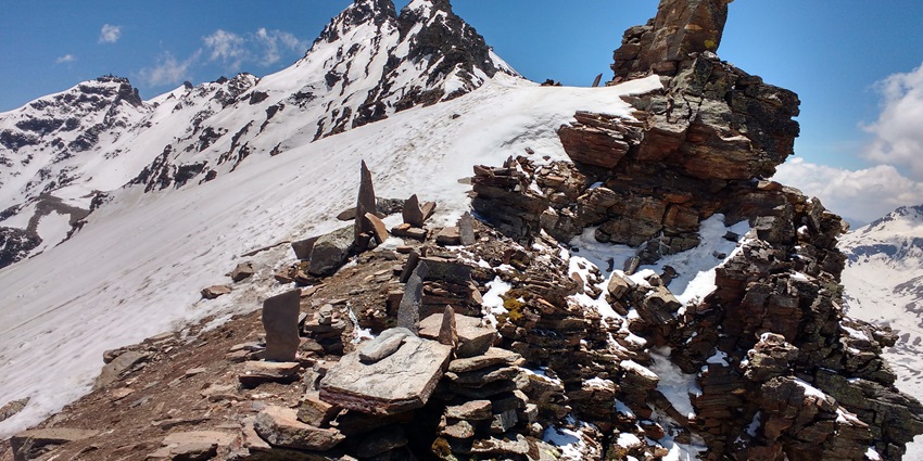 A snowy route on a mountain with rocks