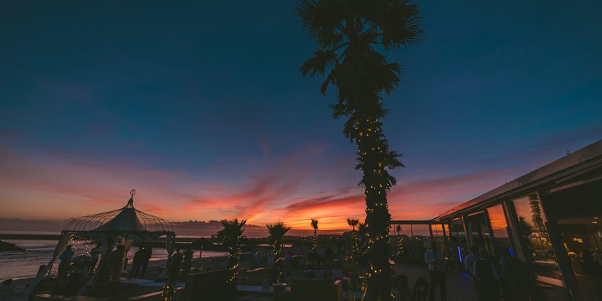 Image of a bar cum cafe near the beach witnessing the beautiful sunset view while sipping your fresh fruit drink