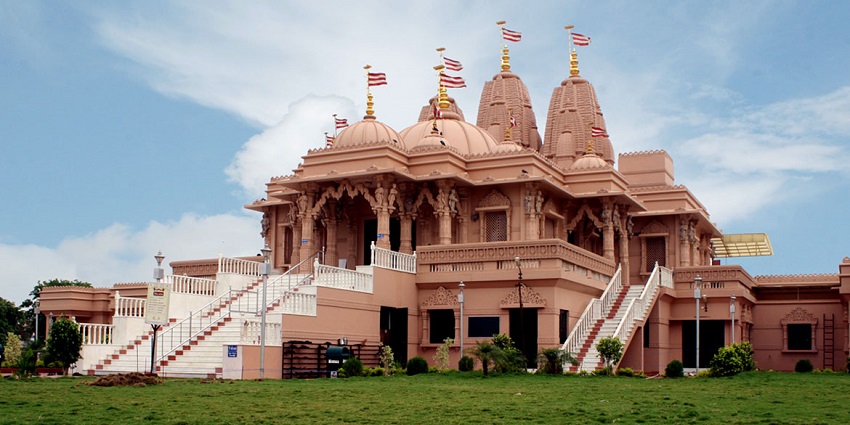 A picture of a traditional Hindu Temple in Dubai with a vast garden in front