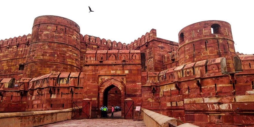 Agra Fort’s red sandstone fortification with domes and walls against blue sky