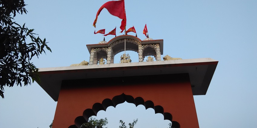 A picture of a scenic temple in Kasauli with views of verdant mountains in the background