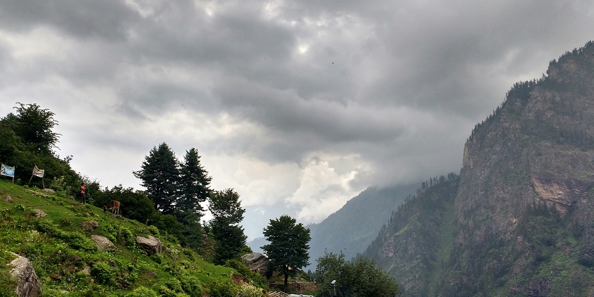 A captivating view of the lush green mountains with a cloudy sky in the background.