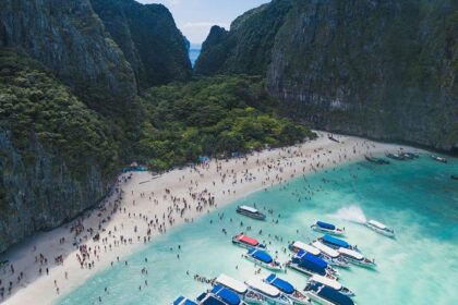 An aerial view of lush greenery, turquoise-blue waters, and golden beaches of Thailand.