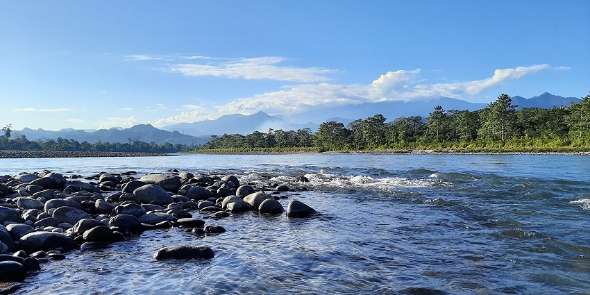 View of a serene lake with rocky shores alongside the lush landscapes of a national park