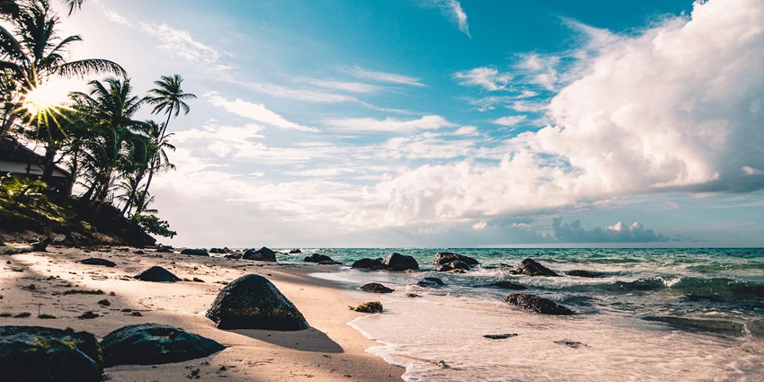 Picturesque seaside view with clear blue waters, sandy shore, and a peaceful atmosphere.