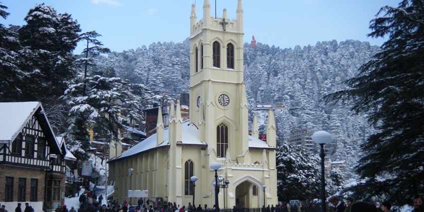 A picture of the majestic Christ Church in Shimla with a cover of snow over it and its surroundings
