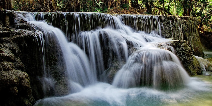Beautiful image of an enchanting waterfall descending on the pool of water in the forest