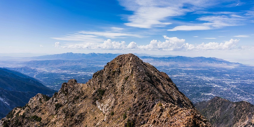 A breathtaking view of an enormous mountain peak under dense clouds during the daytime.