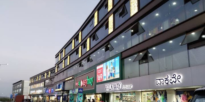 Easy Buy shopping complex in Gandhinagar, showcasing multi-storey storefronts.