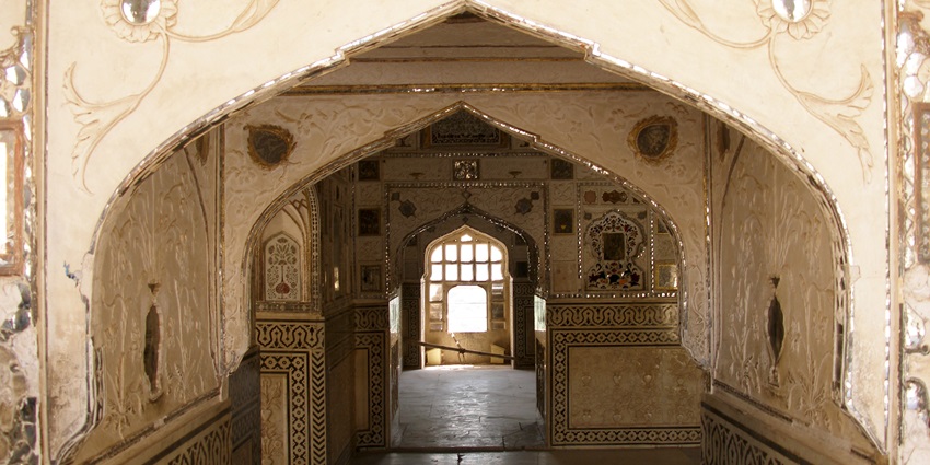 Sheesh Mahal in Amer Fort with ornate mirror walls and golden-hued architecture