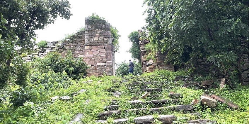 Arched gateway of Shergarh Fort’s citadel with thick red brick walls in ruin.