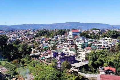 A picture taken from a hill showing the lower city of Shillong during day time