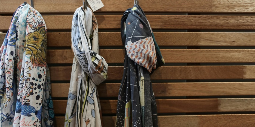 Beautifully patterned shawls in vibrant colors hanging neatly in a wardrobe, showcasing traditional textile artistry, one of the best things to see in Dalhousie in October.