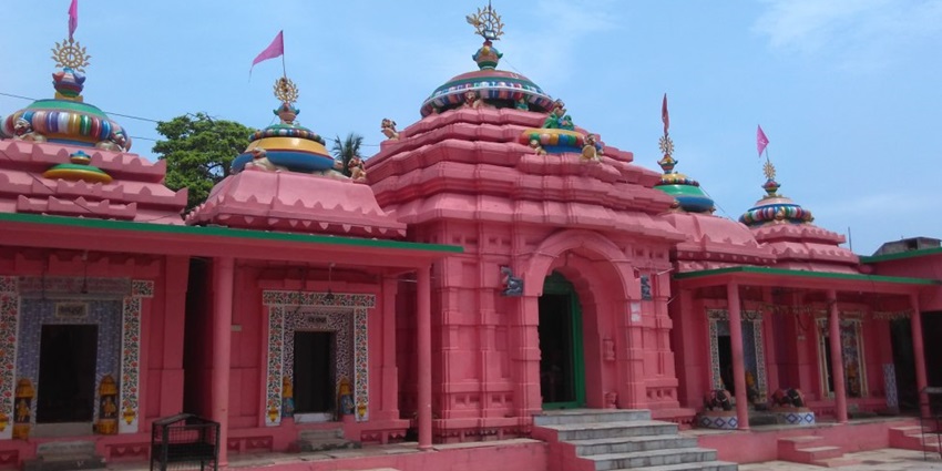 A picture of a temple with red walls and intricate design with traditional architecture