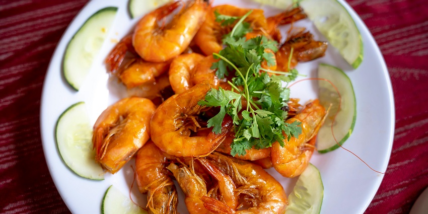 Delicious shrimps dish, expertly cooked and served with a flavorful sauce and garnishes.