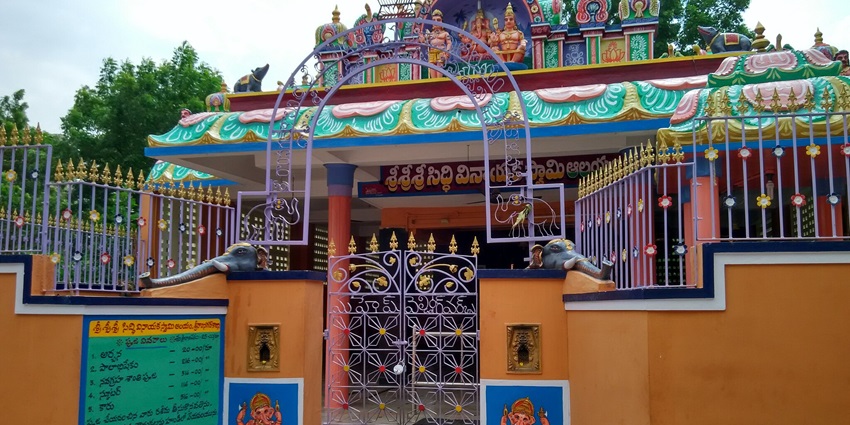 A picture of a temple from outside having colourful walls and paintings of various deities