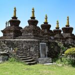 A side view of a monastery in Sikkim covered in lush greenery during the daytime.