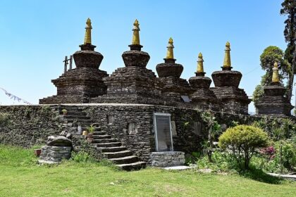 A side view of a monastery in Sikkim covered in lush greenery during the daytime.