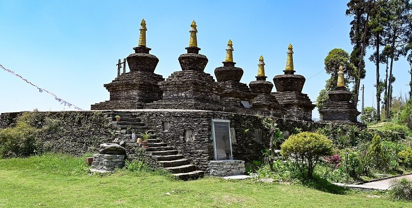 A side view of a monastery in Sikkim covered in lush greenery during the daytime.