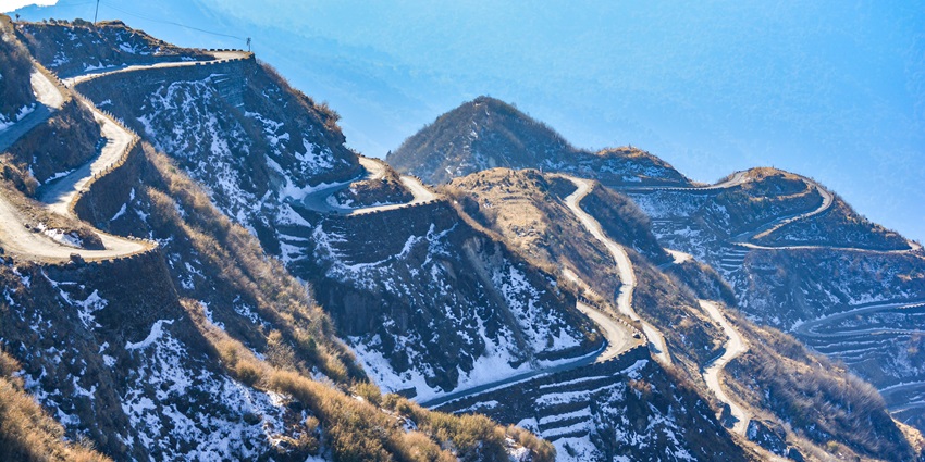 A distant picture of the majestic zig-zag road on the Silk Route with a hint of snow