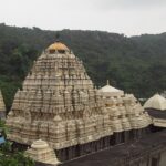 A breathtaking view of a temple in Andhra Pradesh under dense clouds during the daytime.