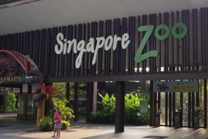 Singapore Zoo entry, showcasing the grand entrance with welcoming signage, lush greenery.