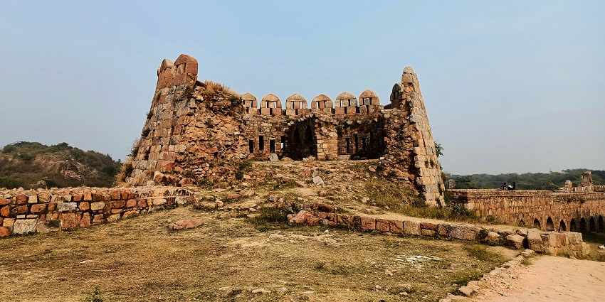 A picture of the ruins of an ancient fort in New Delhi with a clear sky in the background.