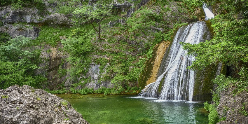 Image of a waterfall surrounded by lush greenery and rocks - take stunning Pasighat photos of waterfall