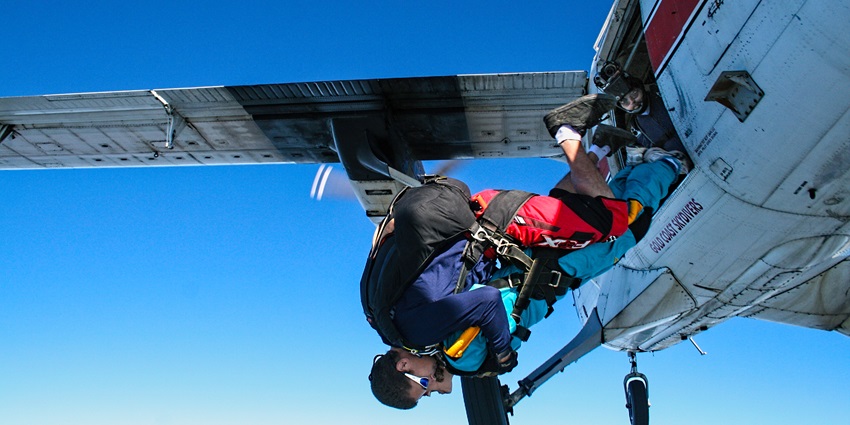 Mid-jump with the aircraft in the background and open skies ahead - skydiving Malaysia