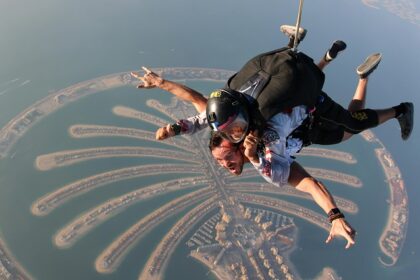 A mesmerising aerial view of two people skydiving over Dubai during the daytime.