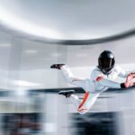 A fascinating view of a person wearing a white suit and a helmet doing an indoor activity.