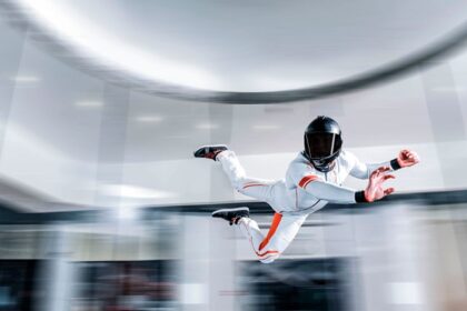 A fascinating view of a person wearing a white suit and a helmet doing an indoor activity.