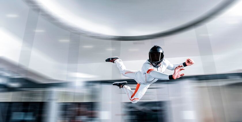 A fascinating view of a person wearing a white suit and a helmet doing an indoor activity.