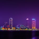 A breathtaking view of a bright skyline in Vietnam seen from a river at night.