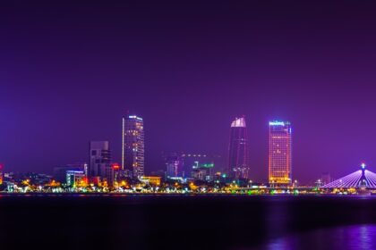 A breathtaking view of a bright skyline in Vietnam seen from a river at night.