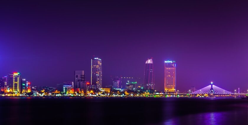 A breathtaking view of a bright skyline in Vietnam seen from a river at night.