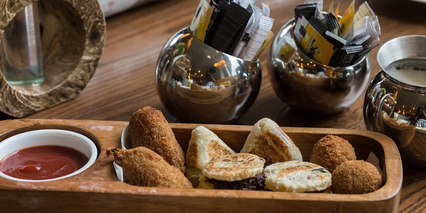 A colourful assortment of Sri Lankan snacks displayed on a plate, featuring various shapes.