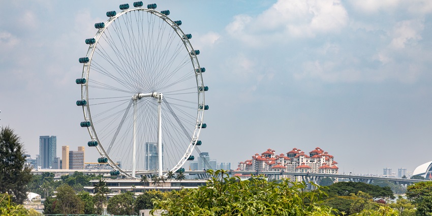 A stunning view of a majestic Ferris wheel in Singapore, surrounded by lush greenery