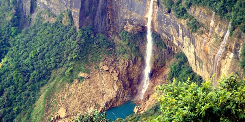 Tall Nohkalikai Falls plunging over a cliff into an emerald green plunge pool–bungee jumping in meghalaya
