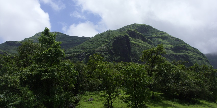 A picture of a lush green mountain, which is one of the best places to visit near Anachadikuthu Waterfalls