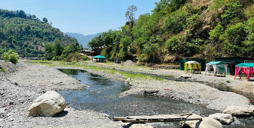 A stunning view of a water body in Solan with lush green surroundings and mountains.