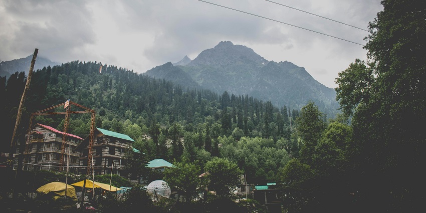 A picture of a valley with a green mountain visible in the background